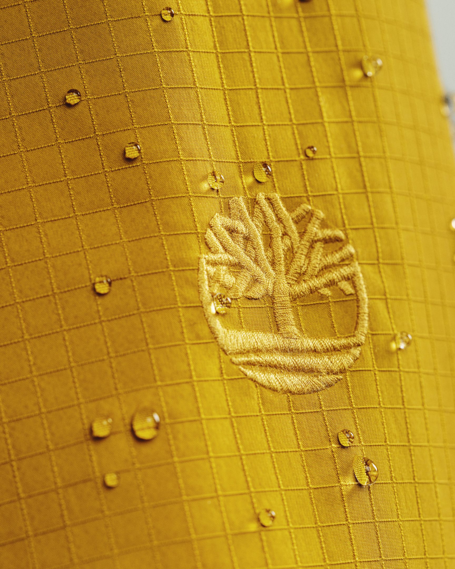 close up of timberland logo on jacket sleeves with water droplets on jacket