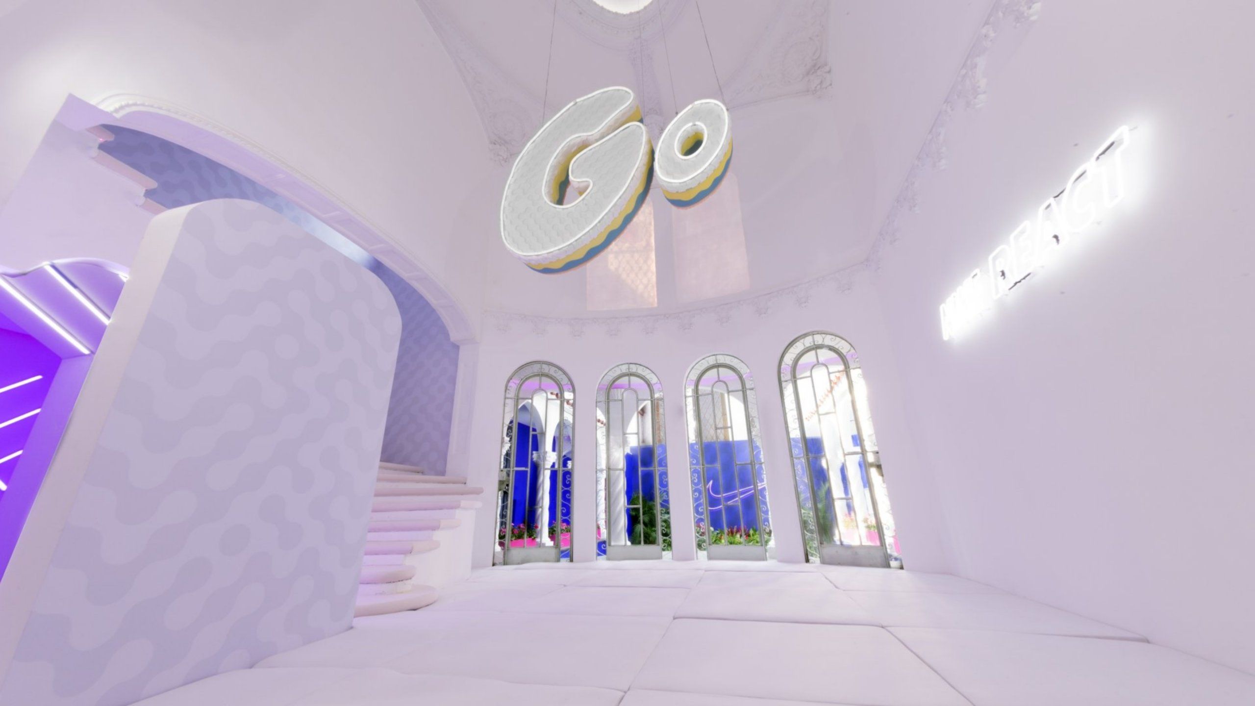 House of Go interior with sign hanging that says Go. Pillow foor, padded staircase adn 4 tall windows