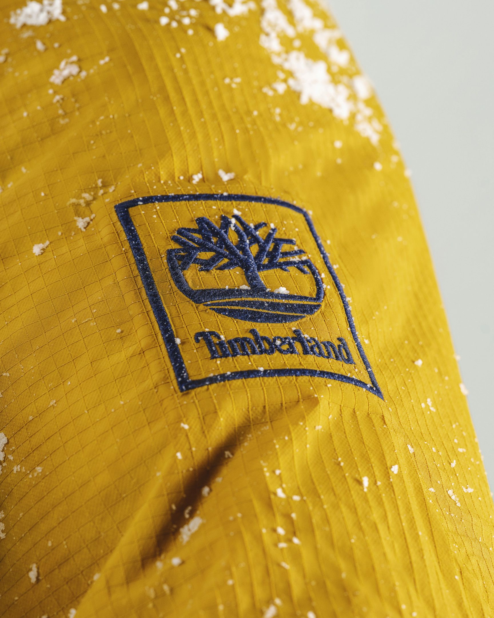 close up of timberland logo on jacket with snow on jacket