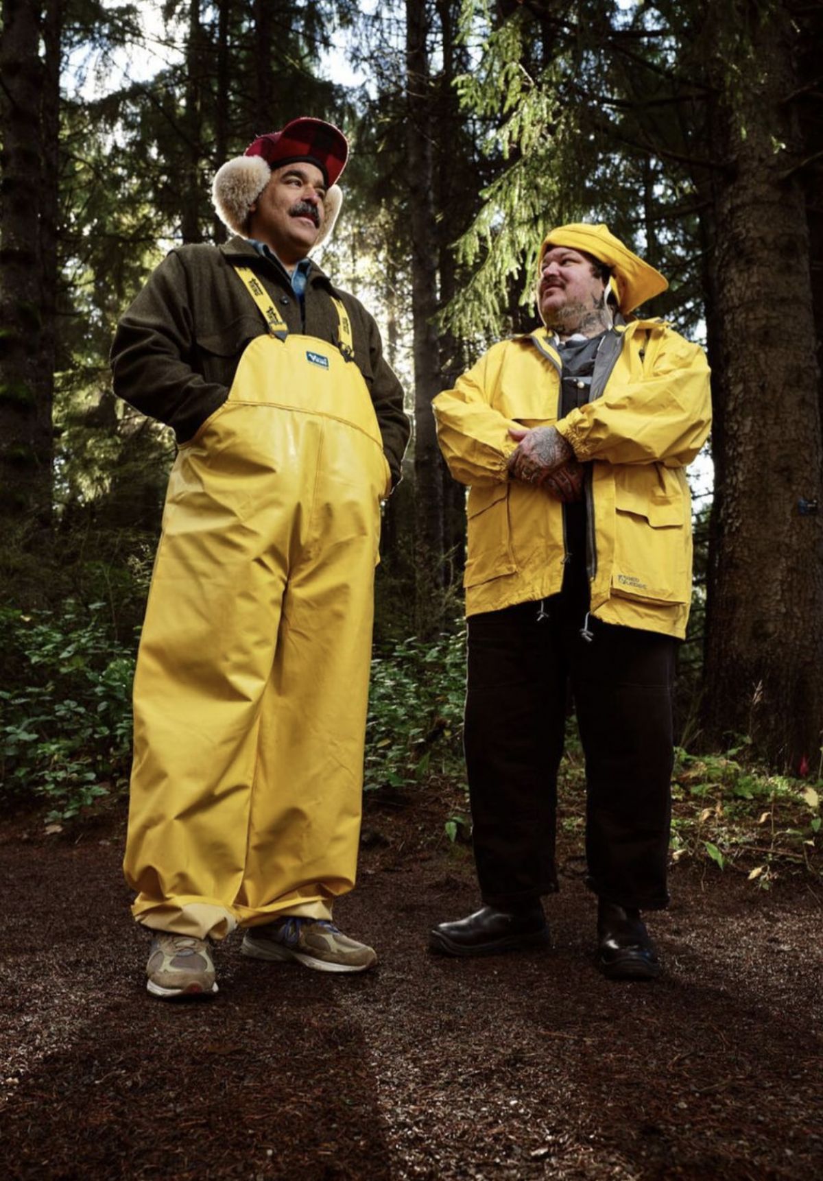 Matty Matheson and Alex 2tone standing in Portland forest with yellow rain gear on.