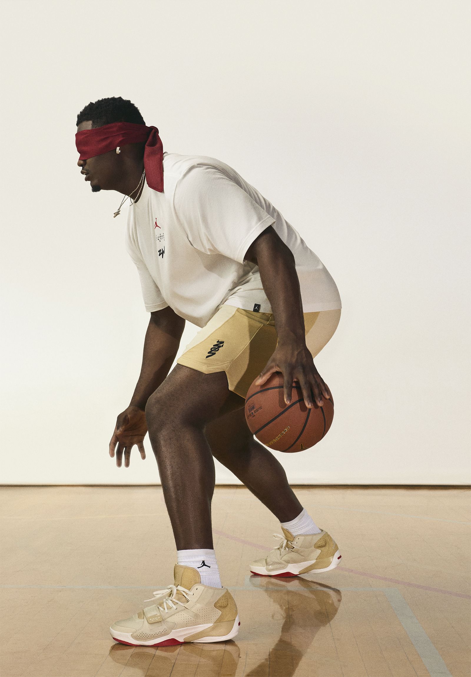 Side view of Zion Williamson dribbling basketball with blindfold on. He is wearing Nike Zion 2 sneakers