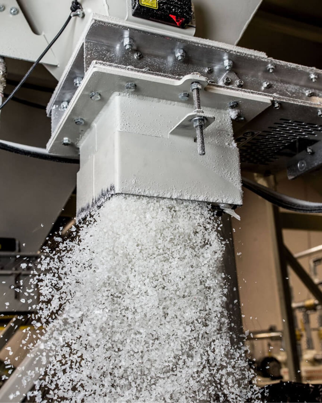 Close up of plastic shavings being discharged from manufacturing machine