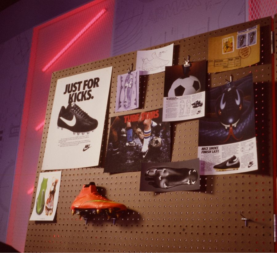 pegboard with prints and shoes showing the history of nike soccer / football boots. Just for Kicks vintage ad is prominent