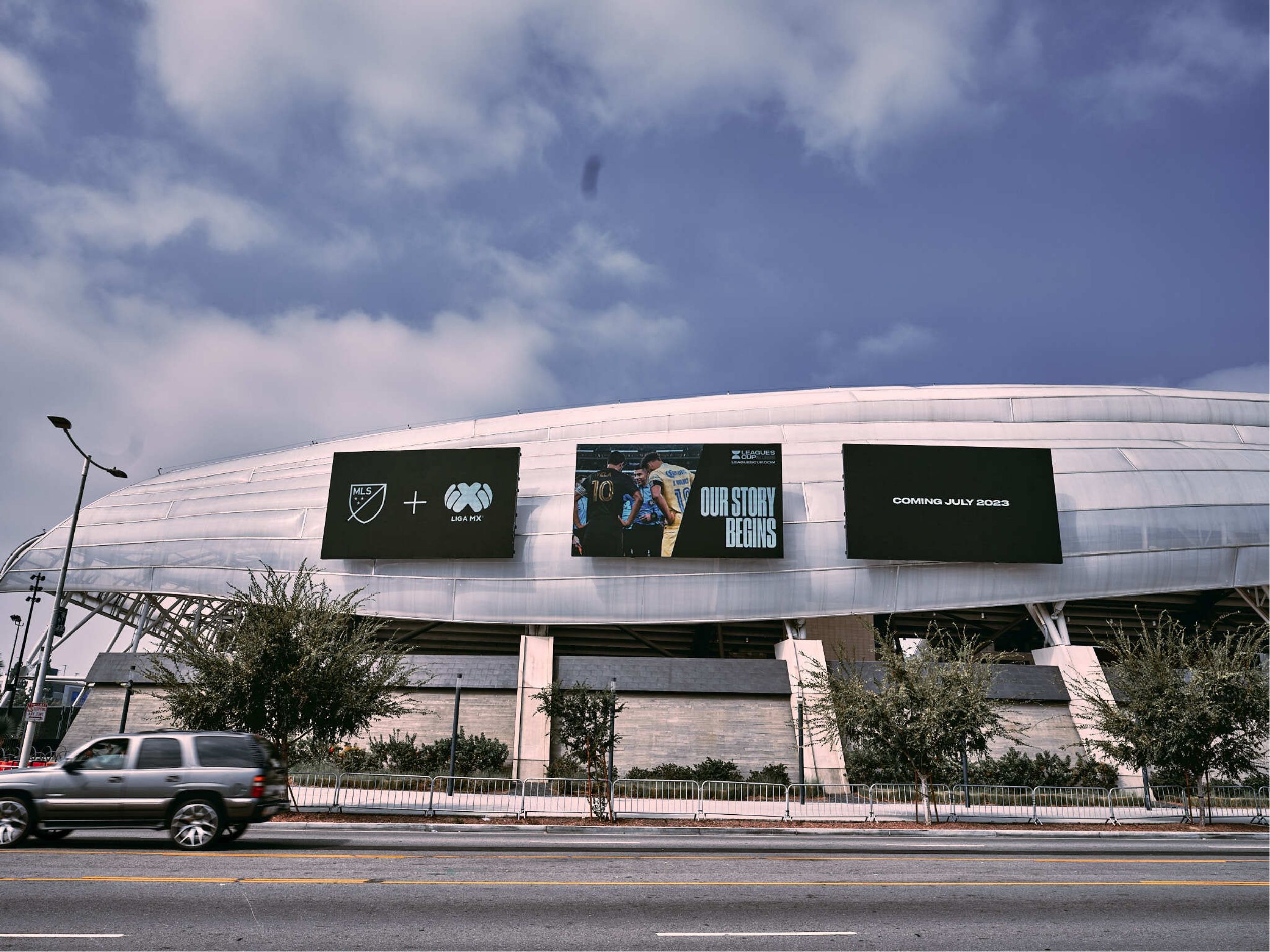 Three Leagues Cup billboard on the side of Banc of California stadium. MLS plus Liga MX. Our Story Begins. Coming July 2023